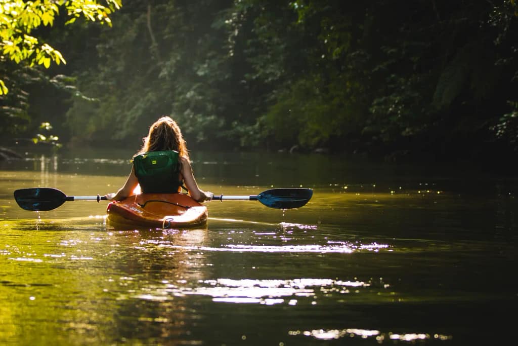 A woman kayaking along the river 
