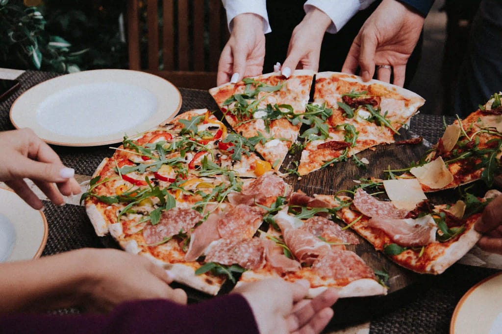 People enjoying a slice of pizza 