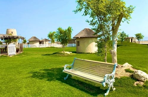 a park with small huts and a wooden chair in 