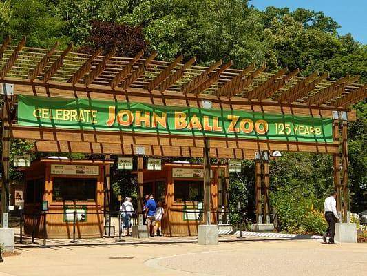 A large wooden house with people walking around (John Ball Zoo)