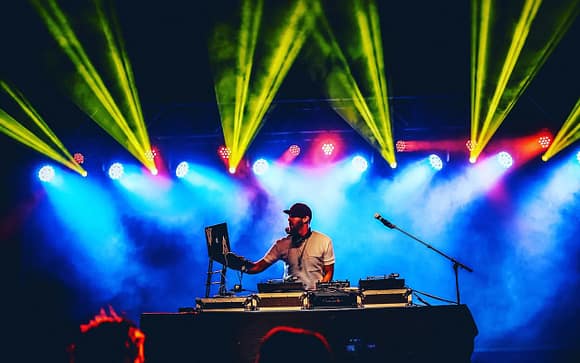 A DJ on stage with multiple lights