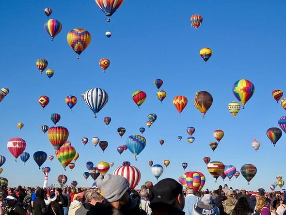 A number of multi-coloured hot air balloons in the sky.