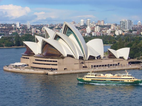 Sydney Opera House showing the large building and a boat 