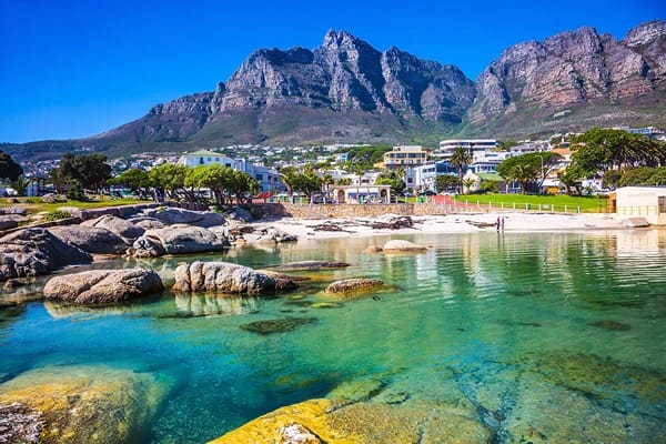 Clear waters surrounded by mountains and buildings 