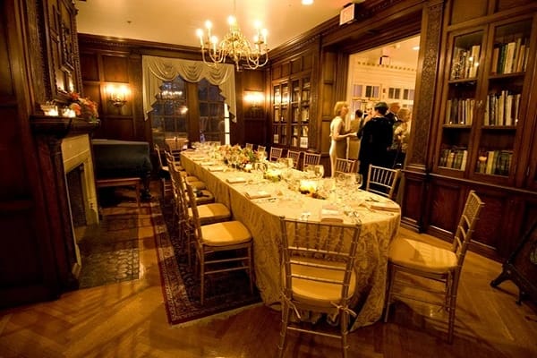A room with a dining table set and guests in Monroe Escape Rooms