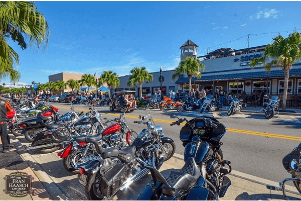 Numerous motorcycles parked on a street