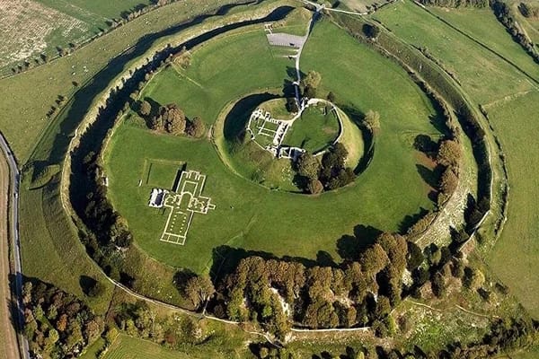 Ariel view of the Old Sarum in Salisbury with trees surrounding it and neatly cut greens. 