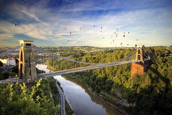 Clifton suspension bridge, Bristol, with various colourful balloons suspended in the air. 
