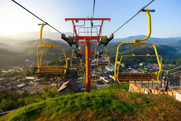 A sky lift over a city with mountains in the background