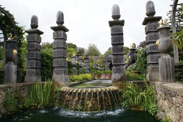 Arundel Castle Gardens, England. Short pillars and flowers with water flowing into a pond