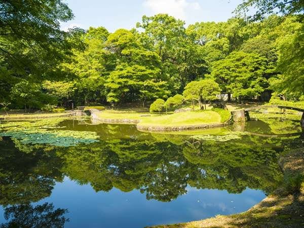 Koishikawa Korakuen Gardens, Japan. A lake surrounded by trees and green low grasses