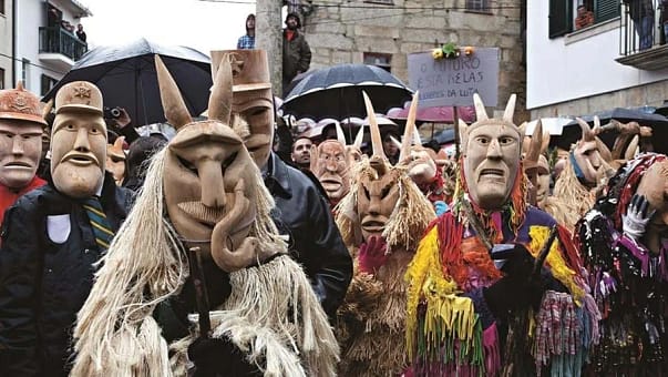 A group of people wearing different wooden masks