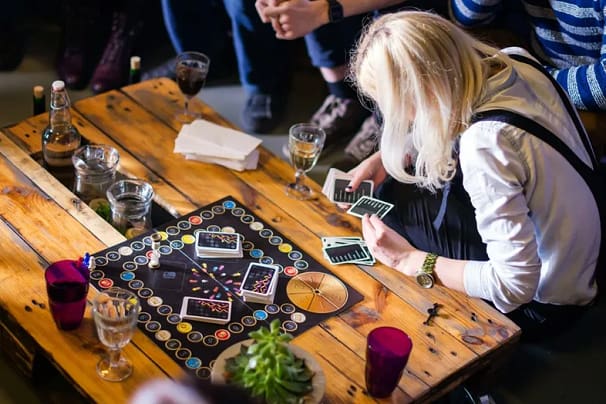 A group of people playing a Board game at a game cafe. 