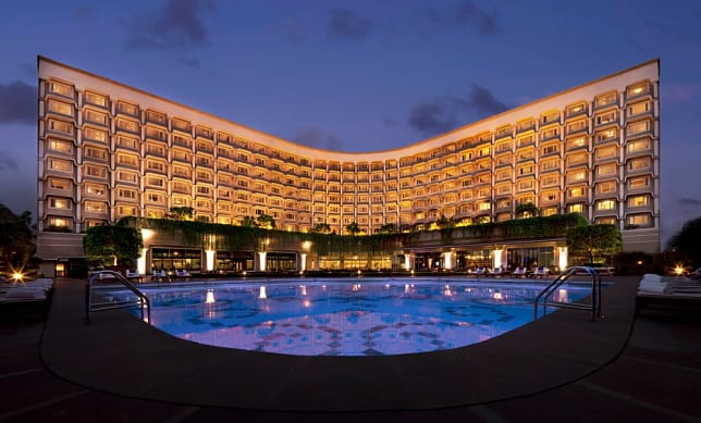 A huge building in the Taj, Palace, New Delhi, in the evening with a glowing pool