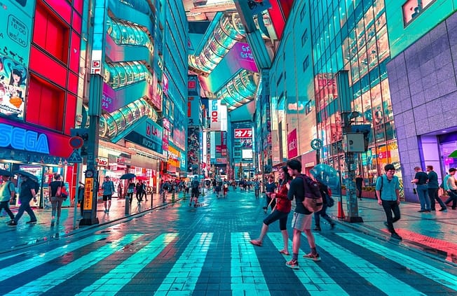 A colorful building in Tokyo, with lots of people walking