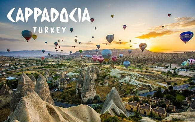 Multiple colored hot air balloons flying over a city in Turkey 