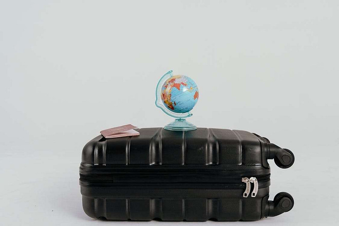 A luggage with a globe on top and a passport/visa