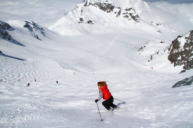 A lady with a red sweater skiing in a snow-covered area