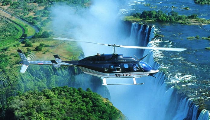 A helicopter flying over a waterfall in the great Zimbabwe Ruins, Mana Pools National Park