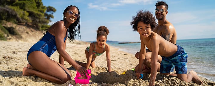 A family (woman, man, a boy and girl child) in a beach having fun
