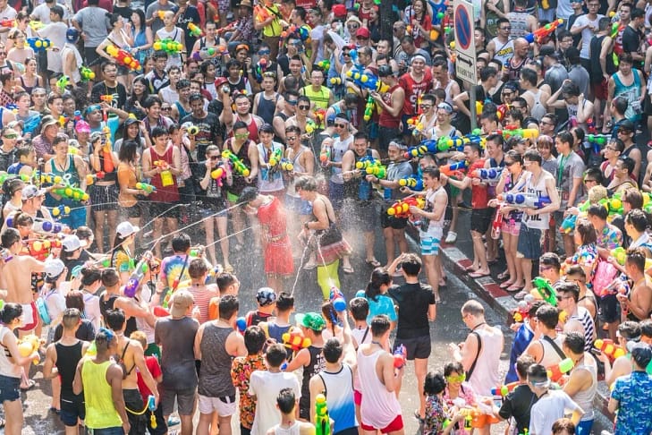 A large crowd of people shooting water guns at each other