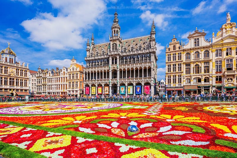 A colorful scene with tall buildings and tourists in La Grand Place, Belgium