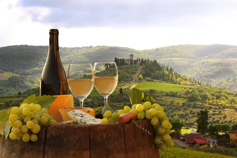 Wine Tasting In Tuscany. A glass bottle and wine glasses with grapefruits on a wooden stand