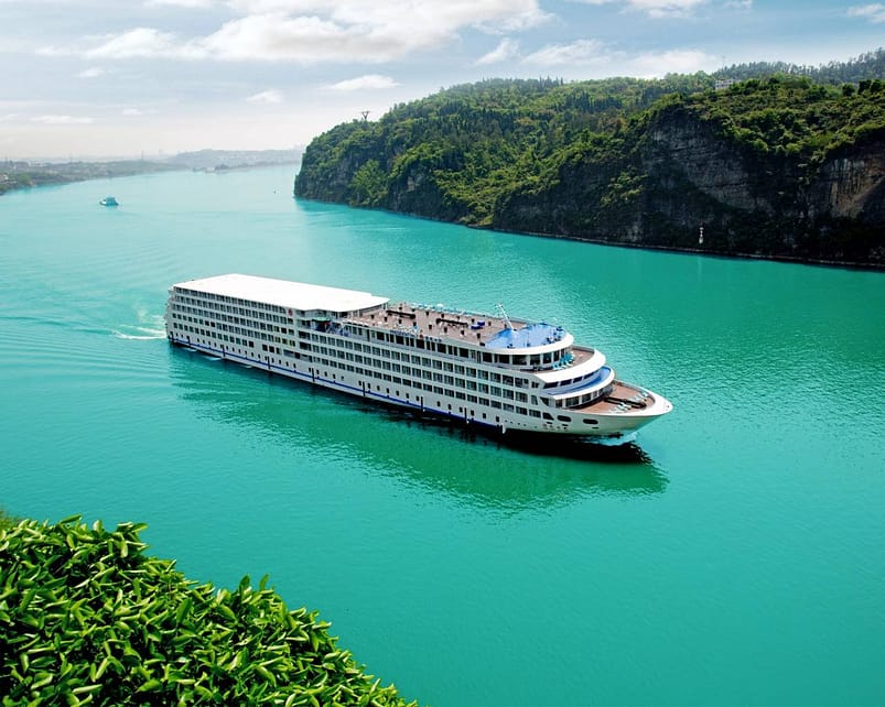 A large white cruise ship on the clear-green waters in The Yangtze Rive