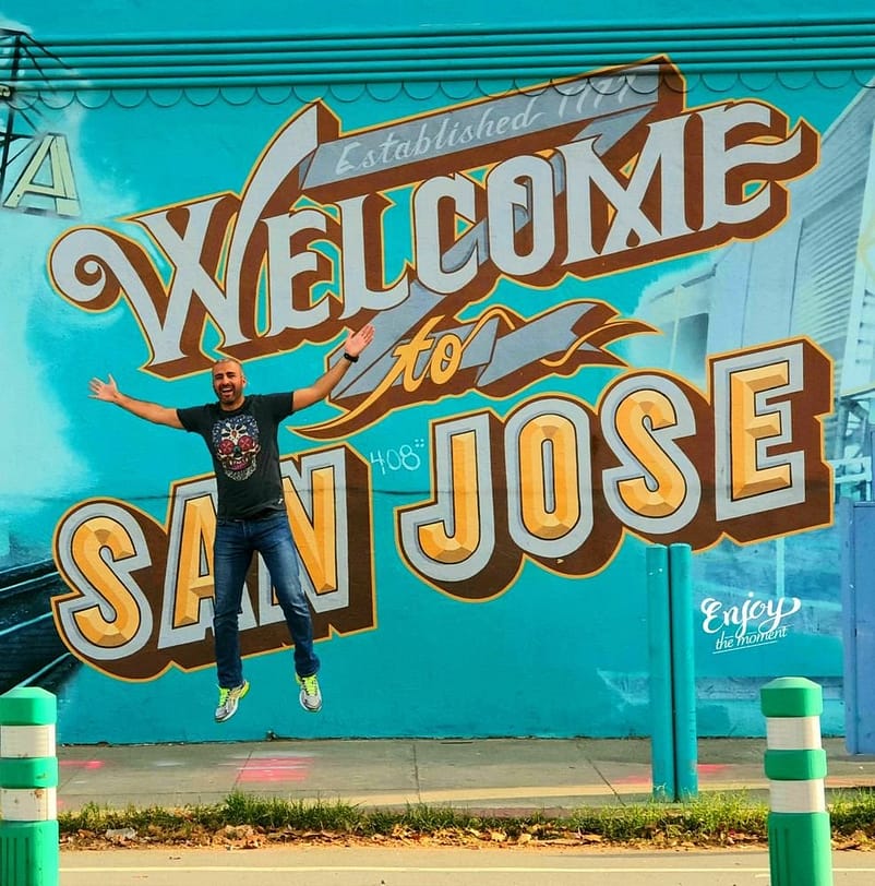 A Graffiti Wall showing a happy man jumping and text inscription behind him that says "Welcome to SAN JOSE"